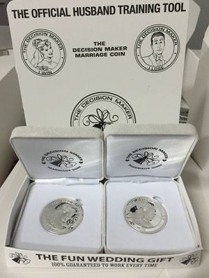 silver-tone novelty coins presented in white boxes labeled as a humorous husband training wedding gift