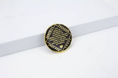 Gold-rimmed black coin with the Serenity Prayer in gold lettering, bordered by Serenity, Freedom and Just for Today