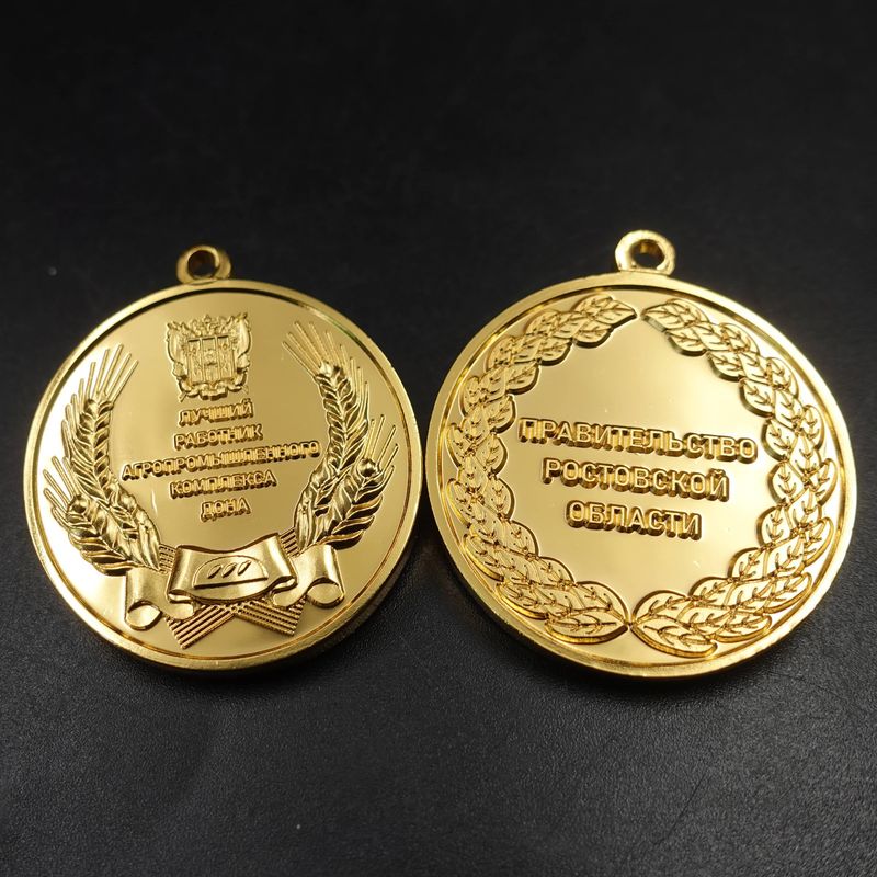 Gold-tone double-sided medallion with laurel wreath and raised Cyrillic lettering