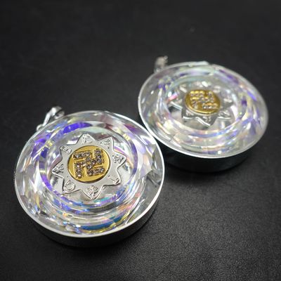 Two round medallions with rainbow-reflective faceted rims and metallic star-shaped centers