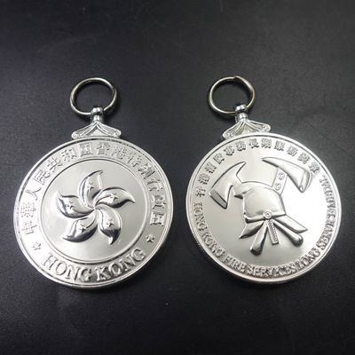 Silver-tone double-sided Hong Kong commemorative hanging medal with floral emblem and crossed symbols