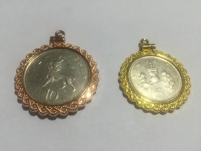 Two coin-style pendant medallions with textured scalloped metal frames and number motifs