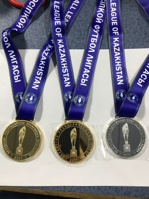 Three round league award medals with purple lettered ribbons and central trophy graphics