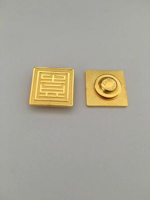 Front and reverse of square gold metal lapel pin with geometric Chinese seal-style pattern and circular rear clasp