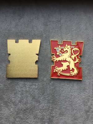 Front and gold back of red castle-shaped heraldic lapel pin with a raised golden lion