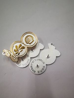 Front and reverse of gold and silver botanical emblem lapel pin set with circular leaf symbols