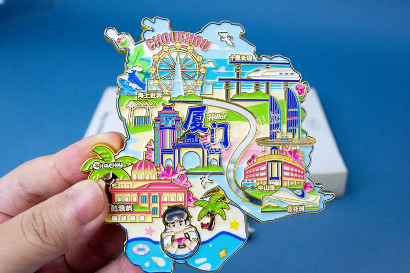 Hand holding colorful layered carnival city souvenir with Ferris wheel and buildings