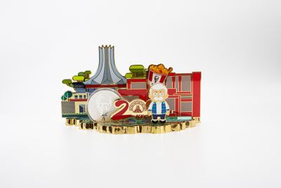 Layered red anniversary cityscape fridge magnet with gold buildings and cartoon figure