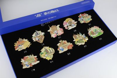 Open blue gift box with nine small colorful landmark souvenir pieces arranged in rows