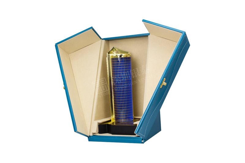 Blue and gold miniature skyscraper model standing in an open blue and cream gift box