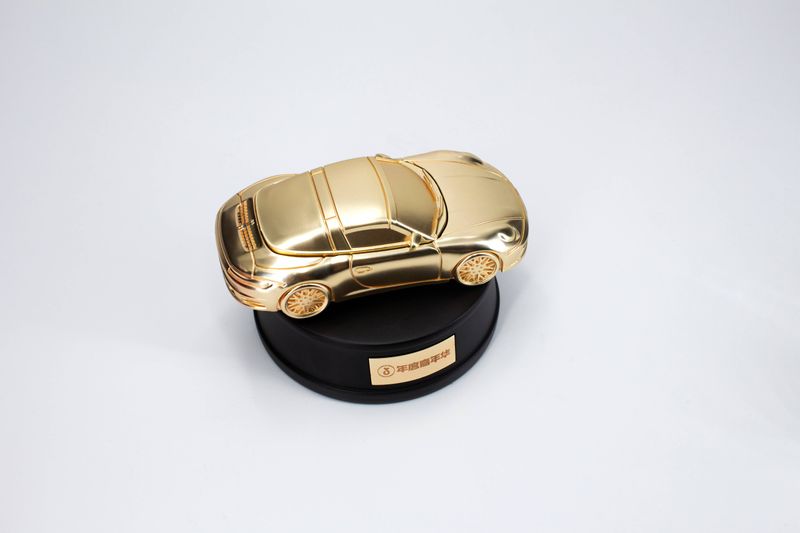 Gold-tone SUV-style miniature car model fixed to a circular black trophy base