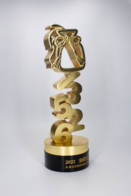 Tall gold vertical numeral trophy with sculptural top emblem and black base bearing 2022