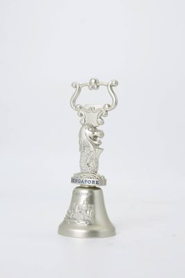 Silver-tone bell-shaped souvenir topped by a merlion figure with Singapore lettering